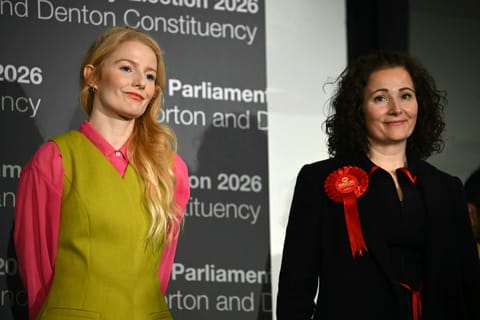 Green Party candidate Hannah Spencer (L) stands alongside Labour party candidate Angeliki Stogia as she is announced as the winner of the Gorton and Denton Parliamentary by-election, at Manchester Central Convention Complex in Manchester, northern England on February 27, 2026.