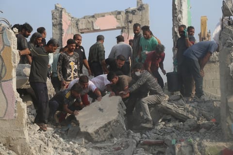 Rescue workers and residents search through the rubble in the aftermath of what Iranian officials said was an Israeli-US strike on a girls' elementary school in Minab, Iran, Saturday, Feb. 28, 2026.
