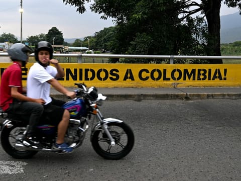 A man riding a motorbike gestures as he crosses the Colombia-Venezuela border at the Simon Bolivar International Bridge on the outskirts of Cucuta, Colombia