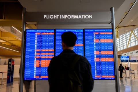A departure board displays multiple canceled and delayed flights at Ronald Reagan Washington National Airport on March 16, 2026 in Arlington, Virginia. Photo used for illustrative purposes.