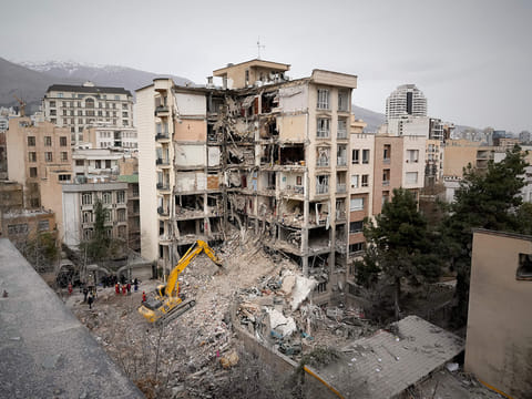 Iranian Red Crescent emergency workers use a bulldozer to clear rubble from a residential building that was hit in an earlier US-Israeli strike in Tehran, Iran, Monday, March 23, 2026.