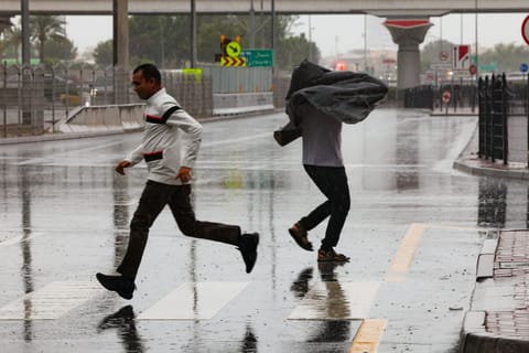 Residents brave the rain at Business Bay in Dubai on Monday.