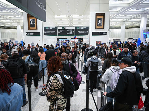 Travellers wait in line at a TSA security checkpoint at George Bush Intercontinental Airport in Houston, Texas on March 20, 2026.