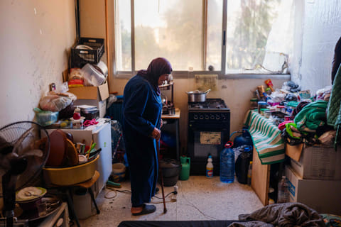 An eldrely displaced woman stands in her room at a school being used as a shelter for displaced people in the southern Lebanese city of Tyre on March 24, 2026. Lebanon was pulled into the Middle East war when Iran-backed Hezbollah began firing rockets into Israel on March 2 to avenge the killing of Iran