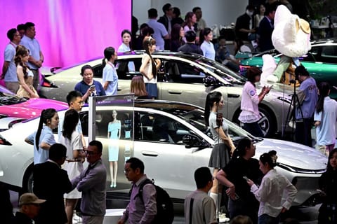 People visit the booth of Chinese automaker Arcfox at the Beijing Auto Show in Beijing on April 25, 2026.