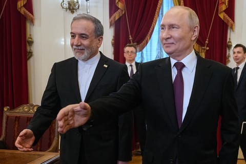 Russian President Vladimir Putin and Iranian Foreign Minister Abbas Araghchi walk to attend the talks at the Boris Yeltsin Presidential Library in Saint Petersburg on April 27, 2026.