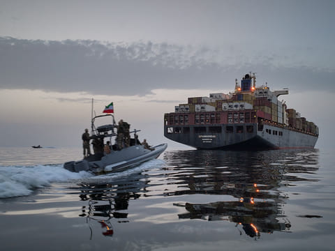 In this photo released by Tasnim News Agency, a Revolutionary Guard Navy (IRGC) speedboat approaches the cargo ship during what state media described as the seizure of one of two vessels accused of violations in the Strait of Hormuz