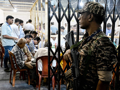 A Central Reserve Police Force (CRPF) personnel stands guard as election officials count votes after the West Bengal Legislative Assembly elections at the Netaji Indoor Stadium in Kolkata on May 4, 2026.