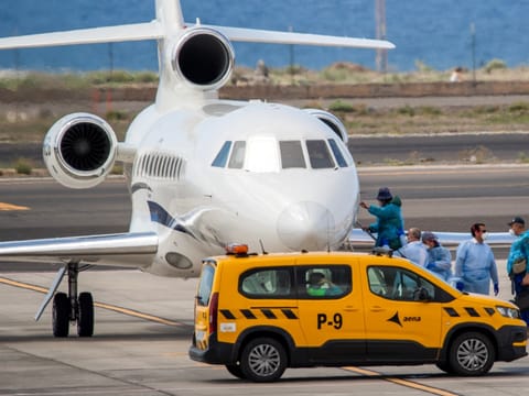 Passengers wearing blue protective suits board a French govenment plane at the Tenerife Sur-Reina Sofia airport after being evacuated from the Dutch flagged hantavirus-stricken cruise ship MV Hondius on the island of Tenerife in Spain's Canary Islands on May 10, 2026