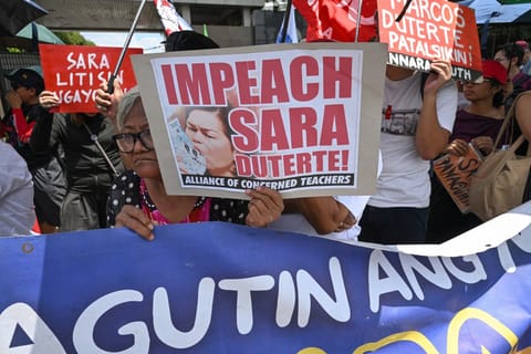 Protesters from progressive groups hold placards during a protest in support of the impeachment of Philippine Vice-President Sara Duterte in front of the Congress building in Quezon City, Metro Manila on May 11, 2026.