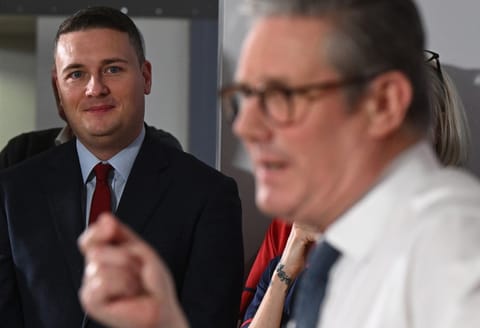 Britain's Health Secretary Wes Streeting (L) listens as Britain's Prime Minister Keir Starmer delivers a speech on a plan to reduce NHS waiting times, during a visit to the South West London Elective Orthopaedic Centre (SWLEOC) in Epsom, south-west of London on January 6, 2025.