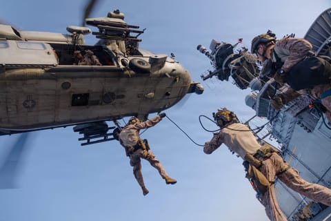 U.S. Marines from the 31st Marine Expeditionary Unit rappel out of an MH-60S Sea Hawk during scheduled training aboard USS Tripoli (LHA 7). Tripoli is one of more than 20 warships supporting the U.S. blockade against Iran. Since the start of the blockade, CENTCOM forces have redirected 72 commercial ships, and disabled 4.