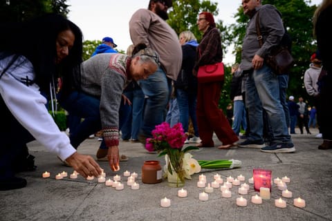 Community members place electric candles near a vase of flowers during a vigil at R.A. Long Park following a fatal chemical storage tank failure on May 26, 2026 in Longview, Washington.