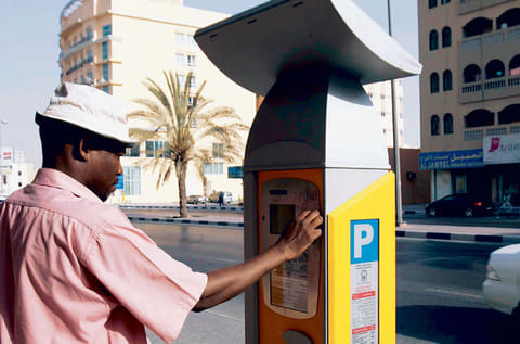 A commuter checks out a parking meter at the Al Yarmook area in Sharjah.