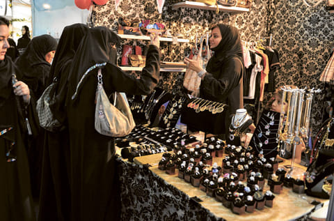 Visitors examine accessories displayed at an exhibition for young Saudi entrepreneurs in Jeddah. Banned from driving and denied the right to travel without permission, Saudi women are taking bold steps in business and trying to do away with the male guardian system that hobbles them.