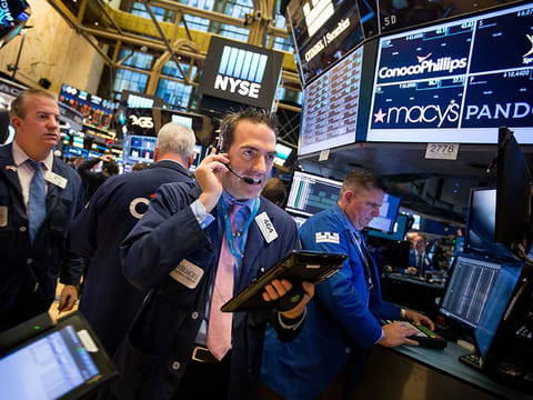 Traders work on the floor of the New York Stock Exchange. With uncertainties regarding US elections fading, some investors expect company earnings and economic data to play a greater role in moving stock prices this year.