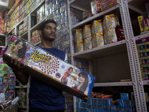 An Indian salesperson carries fire crackers at a shop ahead of Diwali in Hyderabad, India, in a file photo.