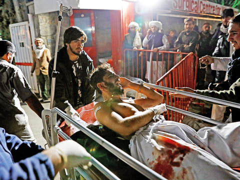 Afghan men carry an injured person to a hospital after a suicide attack in Kabul, Afghanistan November 20, 2018.