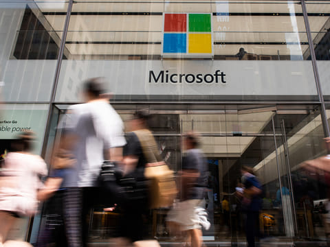 Pedestrians pass in front of the Microsoft Corp. flagship store in New York.