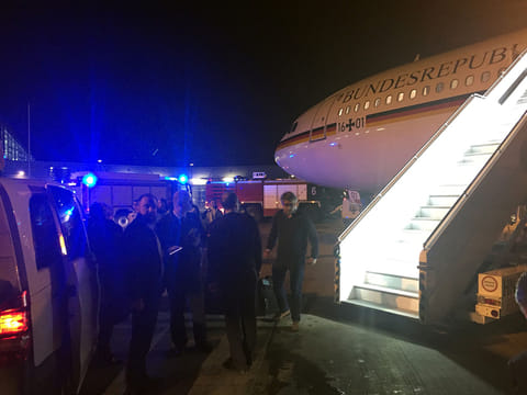 People gather around German Chancellor's Airbus "Konrad Adenauer" on November 29, 2018 on the tarmac of Cologne's airport after an emergency landing.