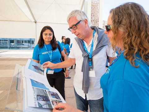 Looking at the FITTEST 20th anniversary photobook: Peter Casier (centre) and WFP staff members