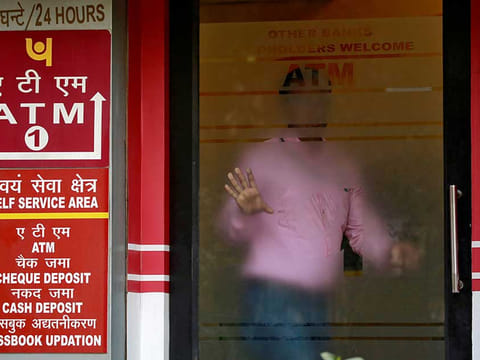 A man leaves an automated teller machine (ATM) facility of Punjab National Bank (PNB) in New Delhi, India.