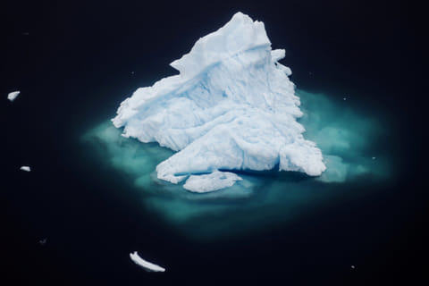 An iceberg floats in a fjord near the town of Tasiilaq, Greenland