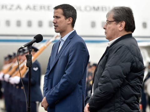 In this photo released by Colombia's presidential press office, Venezuelan opposition leader Juan Guaido, who declared himself interim president of Venezuela, makes a statement as Colombian Foreign Minister Carlos Holmes Trujillo stands by during a welcome ceremony for Guaido at the military airport in Bogota, Colombia, Sunday, Feb. 24, 2019.