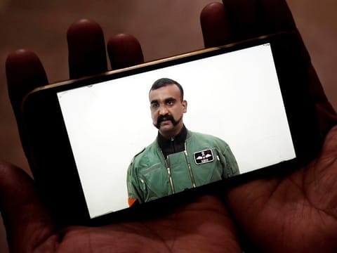 A man watches a statement of Indian Air Force pilot Abhinandan Varthaman on his mobile phone.