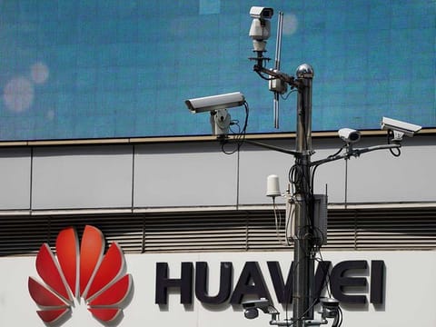 Surveillance cameras are seen next to a Huawei company logo outside a shopping mall in Shanghai, China, March 7, 2019.