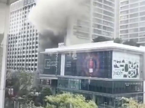 Smoke billows along a street after a fire broke out at Grand Hyatt hotel in Orchard Road, Singapore, March 27, 2019, in this still image taken from a video from social media.