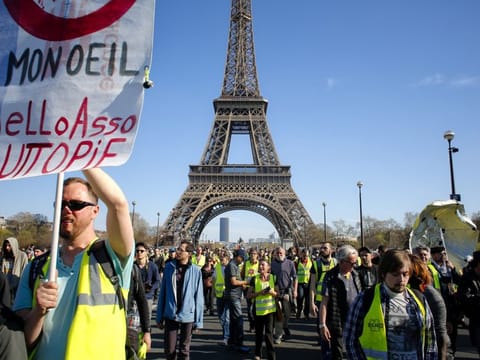 French yellow vest protesters, backdropped by the Eiffel Tower.