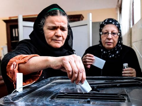 Egyptian women cast their ballots in a box as they vote in a referendum on constitutional amendments, at a school in the capital Cairo's northern neighbourhood of Shubra, on the first day of a three-day poll, on April 20, 2019.