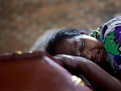 Sri Lankan woman Lalitha weeps on the coffin with the remains of 12-year old niece, Sneha Savindi, who was a victim of Easter Sunday bombing at St. Sebastian Church in Negombo, Sri Lanka, Monday, April 22, 2019.
