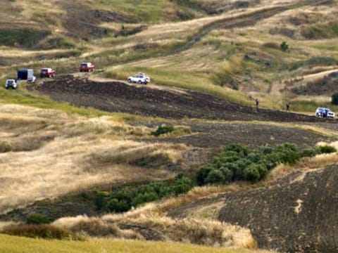 Cypriot investigators and police officers search a field where a body were found, outside of Orounta village, near the capital Nicosia, Cyprus