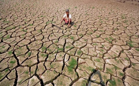 A farmer sits on his parched paddy field in a village near Latur, Maharastra, India. Extreme weather conditions impact the marginalised and those in the unorganised sector the most; it also causes economic damage and loss of life.