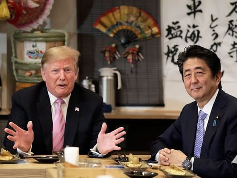 US President Donald Trump, left, speaks as Shinzo Abe, Japan's prime minister, sits at a counter during a dinner at the Inakaya restaurant in the Roppongi district of Tokyo, Japan, on Sunday, May 26, 2019.