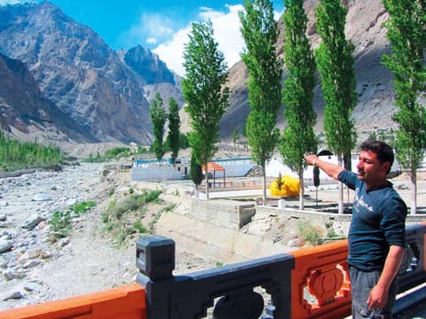 A villager points towards the Shishper Glacier, near the Karakoram Highway in Hassanabad village in Hunza district.