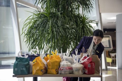 At rush hour, delivery services leave takeout orders in the lobbies of office buildings to save time, in Beijing
