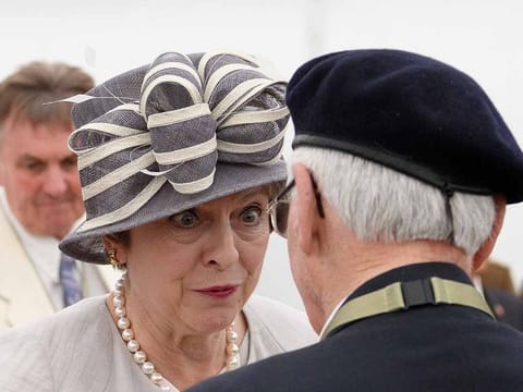British Prime Minister Theresa May chats with veteran William Bennett following a service of remembrance at Bayeux cemetery in Bayeux, France, June 6, 2019.