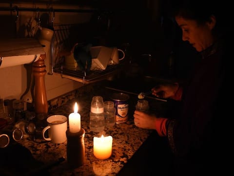 A woman prepares milk bottles during a power cut. Illustrative image.