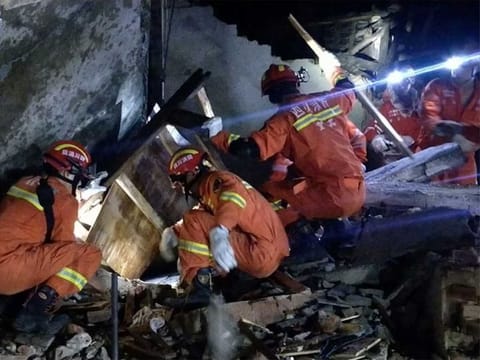 Rescuers search for earthquake survivors in the rubble of a building in Yibin, in China's Sichuan province