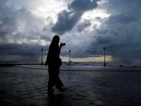 File picture: A woman takes photographs with her mobile phone against the backdrop of monsoon clouds at a beach in Kochi, India, June 8, 2019.