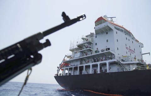 Sailors stand on deck above a hole the U.S. Navy says was made by a limpet mine on the damaged Panama-flagged, Japanese owned oil tanker Kokuka Courageous, anchored off Fujairah, United Arab Emirates, during a trip organized by the Navy for journalists, Wednesday, June 19, 2019.