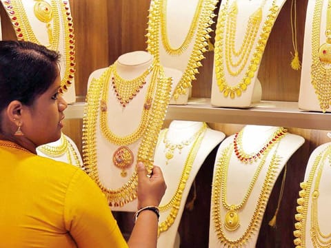 File photo: A saleswoman selects gold necklaces in a jewellery showroom in India.