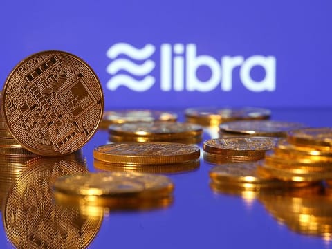 Representations of virtual currency are displayed in front of the Libra logo in this illustration picture.