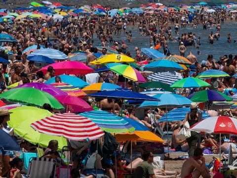 People swarm a public beach amid a heatwave in Valencia, Spain.