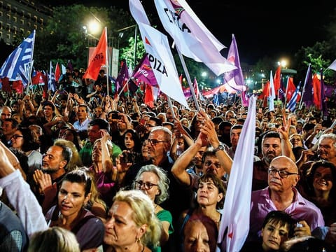 Supporters of Syriza party hold flags as they take part in a pre-election rally in Athens on July 5, 2019, two days ahead of general elections.