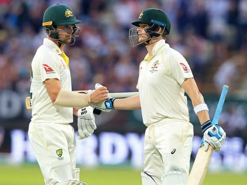 Australia's Travis Head (L) gestures to Australia's Steve Smith (R) during play on the third day of the first Ashes cricket test match at Edgbaston in Birmingham, central England on August 3, 2019.