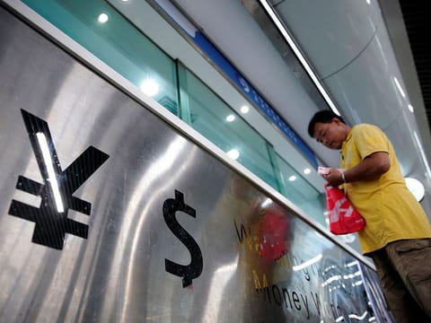 Spreading the wealth around requires the right sort of tech support. File photo of the yuan and dollar signs at a currency exchange outlet in China.